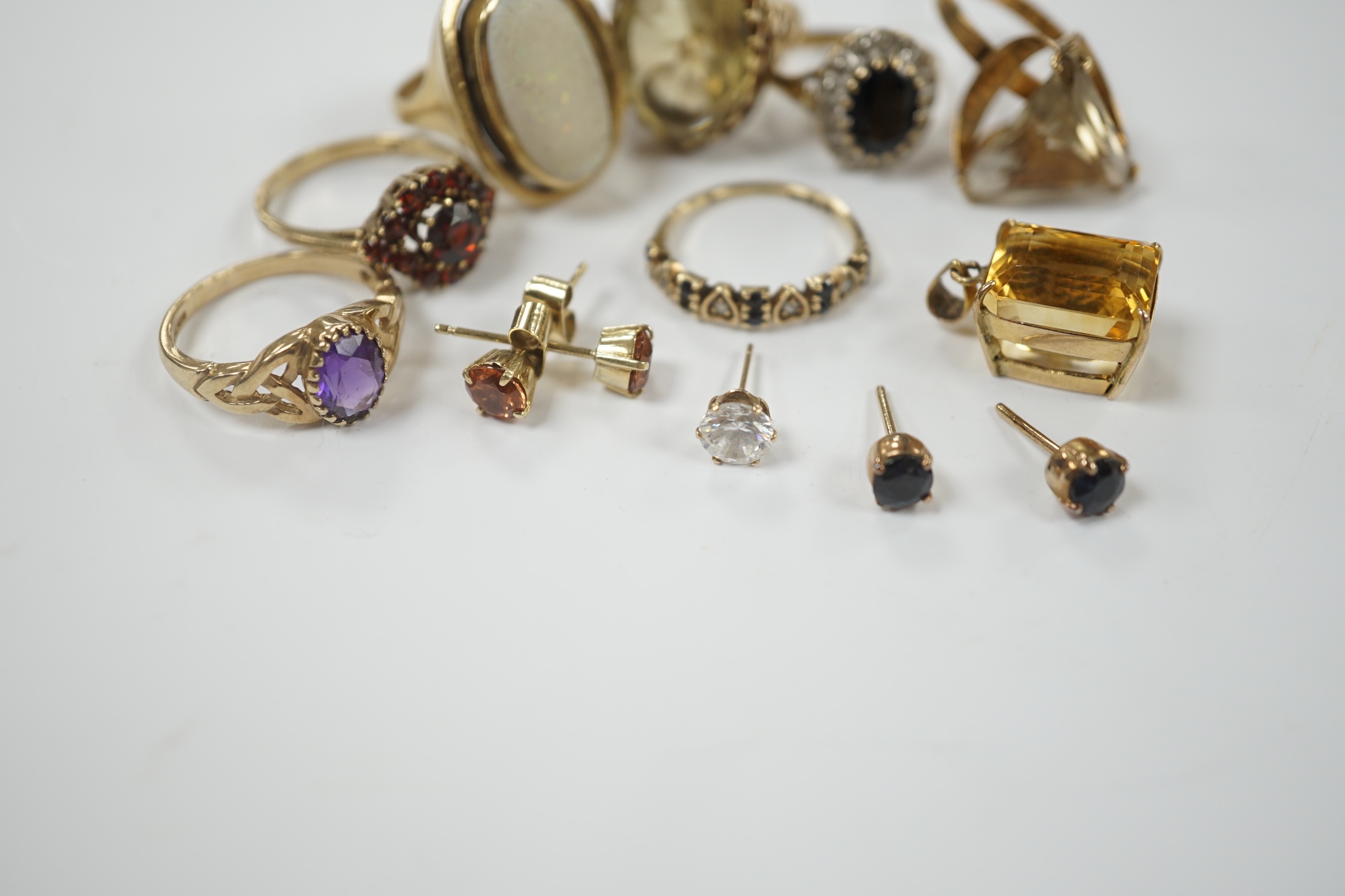 Seven assorted modern 9ct and gem set rings, including garnet cluster, white opal and amethyst, gross weight 26.2 grams, together with a pendant and assorted ear studs.